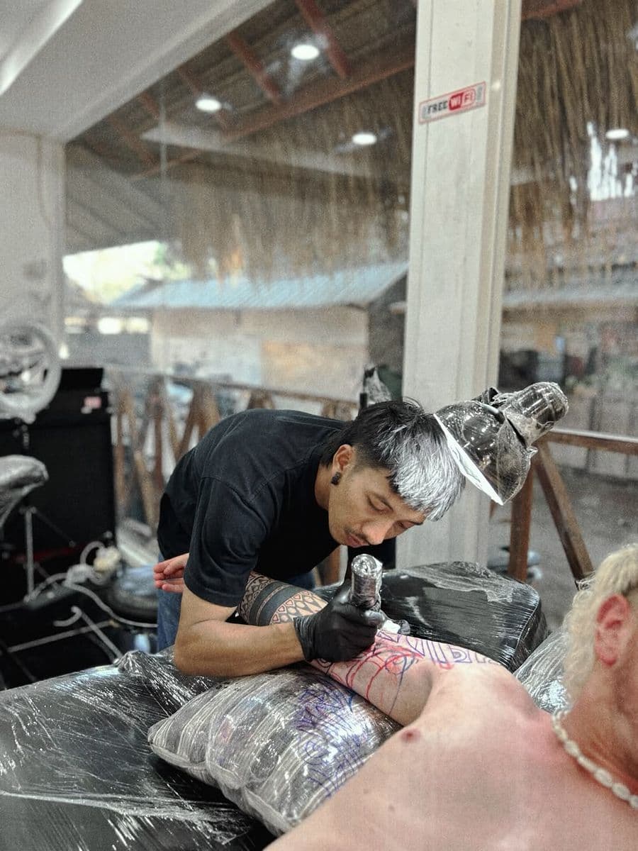 MG sedang menato klien di studio