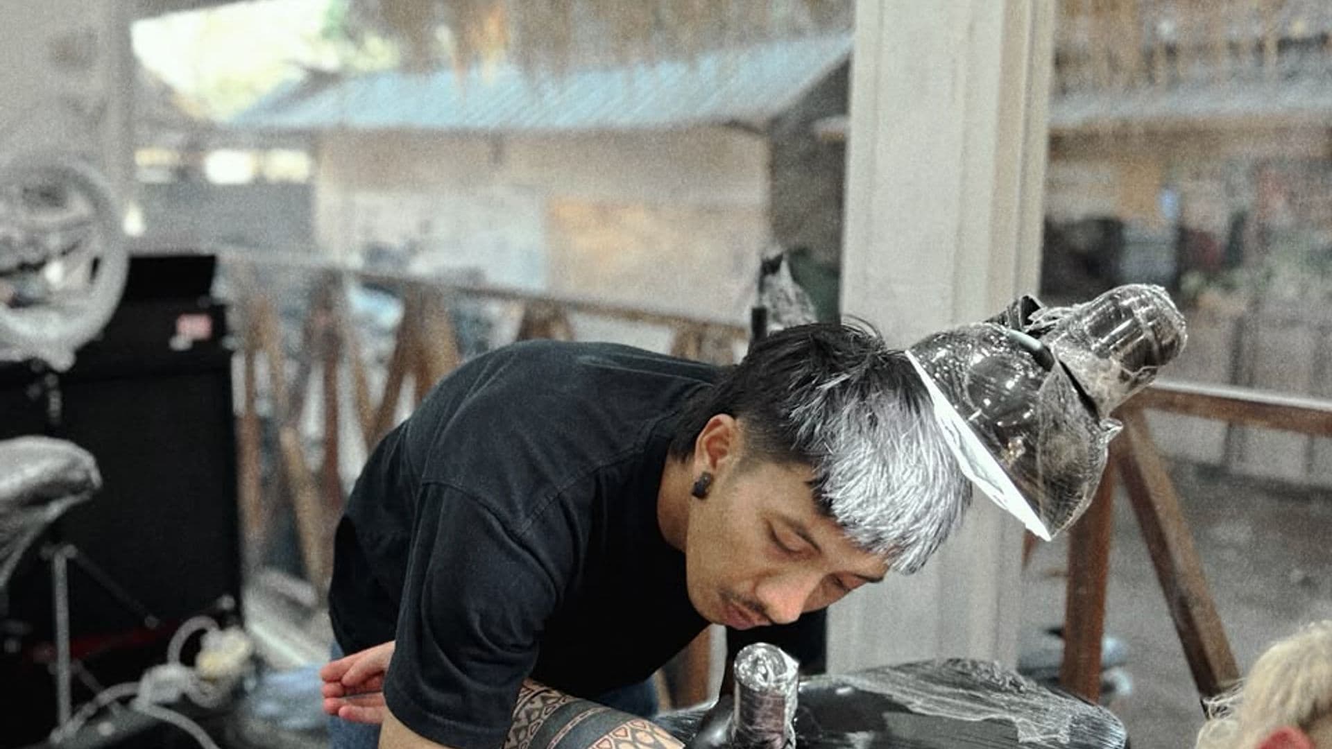 MG tattooing a client in the studio